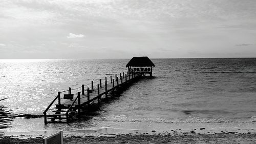 Pier at beach against sky