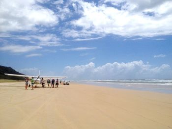 People on beach against sky