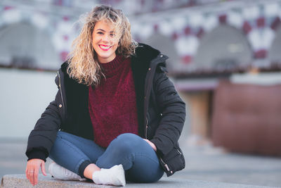 Portrait of smiling young woman sitting outdoors