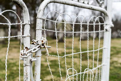 Close-up of barbed wire fence on field