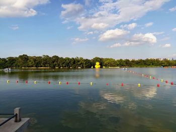 Scenic view of swimming pool by lake against sky