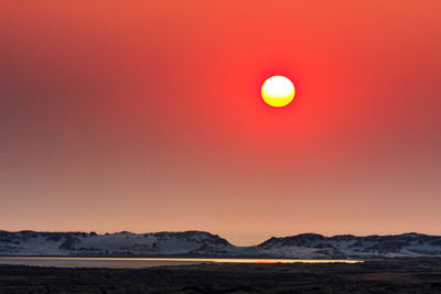 Scenic view of sea against orange sky