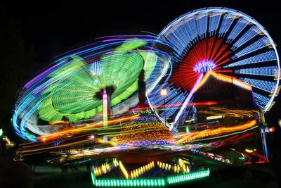 Low angle view of illuminated ferris wheel against sky at night