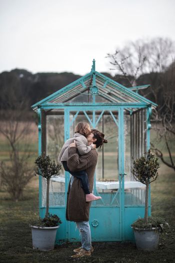 Full length of mother carrying girl on field while standing on field