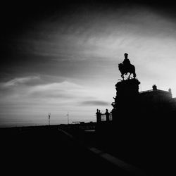 Silhouette statue against sky at sunset