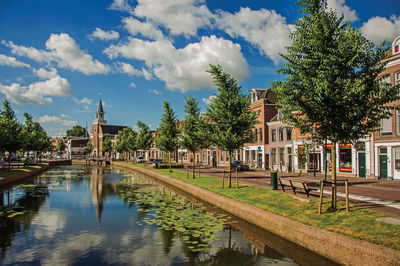 Canal with bascule bridge, church and townhouses in weesp. a pleasant small village in netherlands.