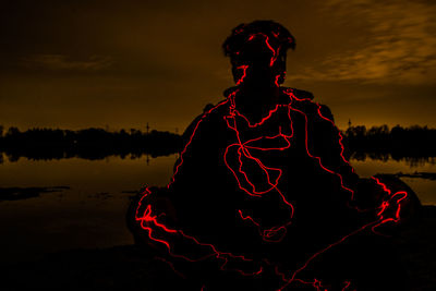 Man with red umbrella at night