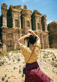 Rear view of woman against old ruins