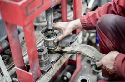 Midsection of man working on metal