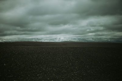 Scenic view of land against cloudy sky