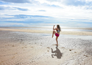 Young woman exercising at beach