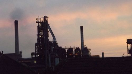 Low angle view of crane against cloudy sky