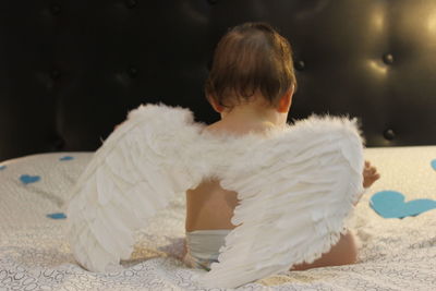 Close-up of cute baby with wings at home