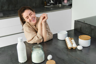 Portrait of smiling young woman sitting on table