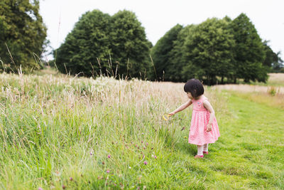 Side view of girl standing on grassy land