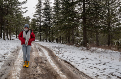 Man standing on snow covered forest