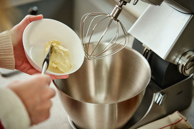 Woman cooking at home kitchen, use electric mixer to preparing dough