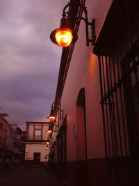 Illuminated street light in city at dusk