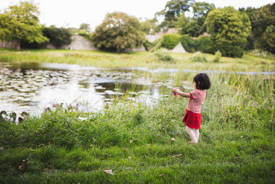 Side view of girl standing on grassy land