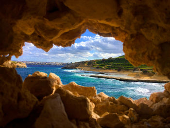 Scenic view of sea seen through cave