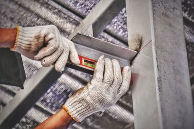 Close-up of man hands checking level of metal with spirit