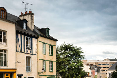 Low angle view of buildings against cloudy sky