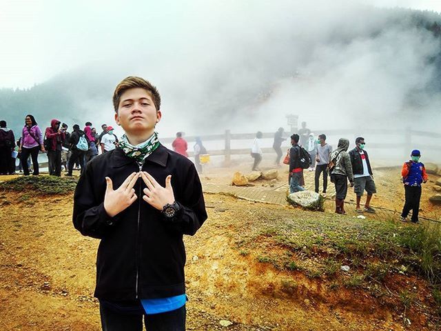 lifestyles, sky, leisure activity, casual clothing, cloud - sky, looking at camera, standing, cloudy, portrait, person, happiness, field, weather, front view, full length, landscape, day, nature, overcast