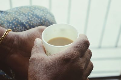 Cropped image of hand holding tea cup