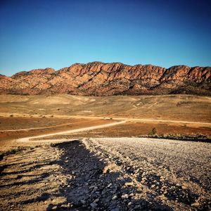 Scenic view of landscape and mountains against clear blue sky