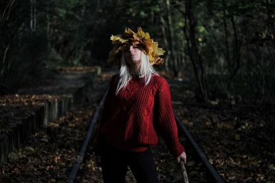 Midsection of woman standing by tree in forest