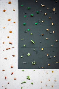 Artificial rock climbing wall showing various colored grips at outdoor gym adventure park.