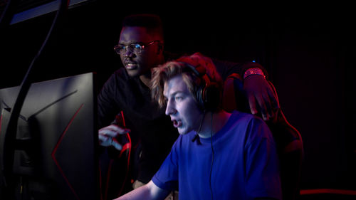 Men playing video game in darkroom