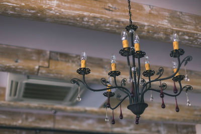 Low angle view of illuminated lighting equipment hanging on ceiling
