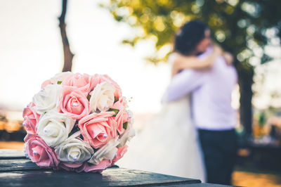 Close-up of rose bouquet with couple in background