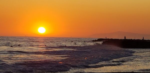 Scenic view of sea against orange sky