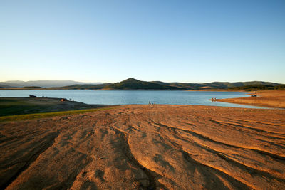 Scenic view of beach against clear blue sky