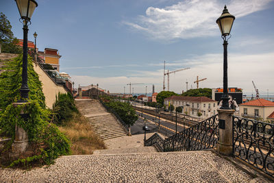 Street lights by railroad tracks against sky