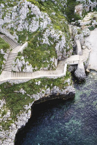 High angle view of stairway on cliff by sea