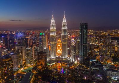 Illuminated cityscape against sky at night