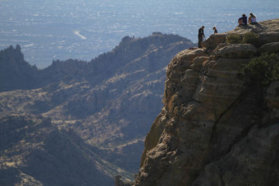 People on rock by mountains tucson arizona