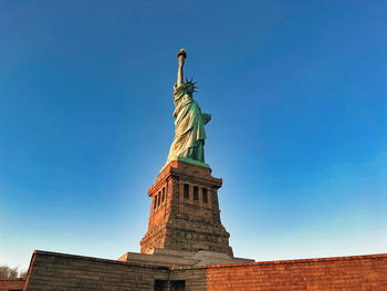 Low angle view of statue against clear blue sky