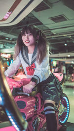 Portrait of smiling young woman sitting in city