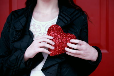 Midsection of woman holding strawberries