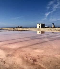 Built structure on beach against blue sky