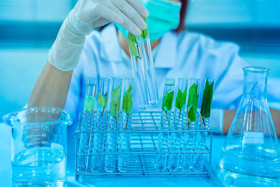 Midsection of scientist examining chemical in laboratory