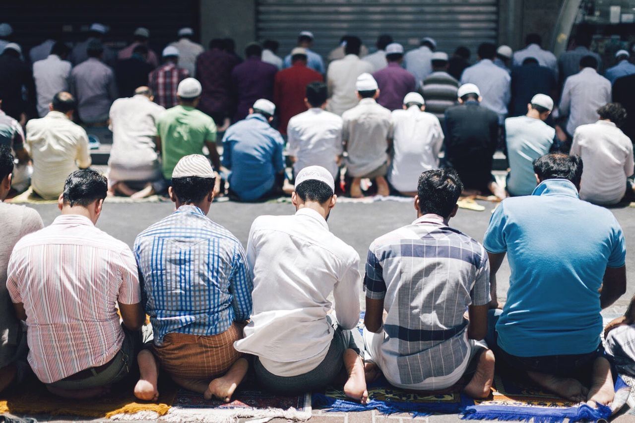large group of people, men, person, lifestyles, crowd, leisure activity, togetherness, sitting, street, rear view, standing, casual clothing, walking, mixed age range, day, medium group of people, group of people, outdoors, city