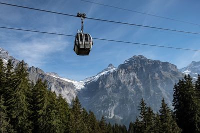 Low angle view of overhead cable car against sky