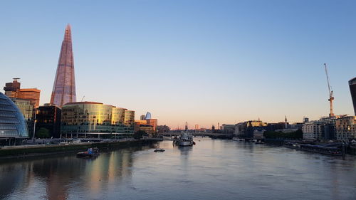 Rover by buildings in city against sky at sunset