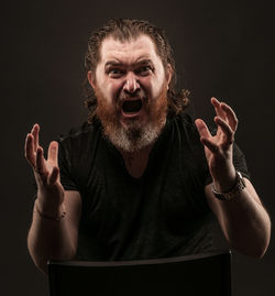 Portrait of worried man against black background