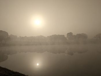 Scenic view of lake against sky during foggy weather